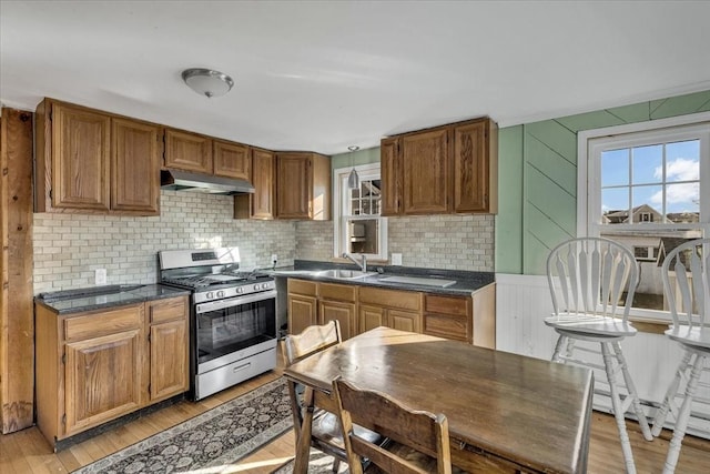 kitchen featuring gas stove, backsplash, light hardwood / wood-style flooring, and sink