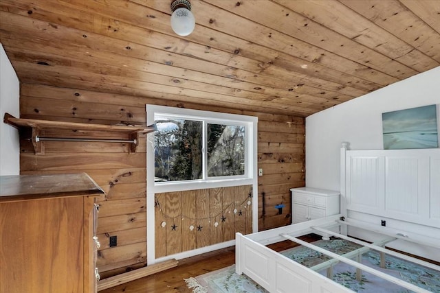 bedroom featuring wood-type flooring, wooden walls, lofted ceiling, and wooden ceiling