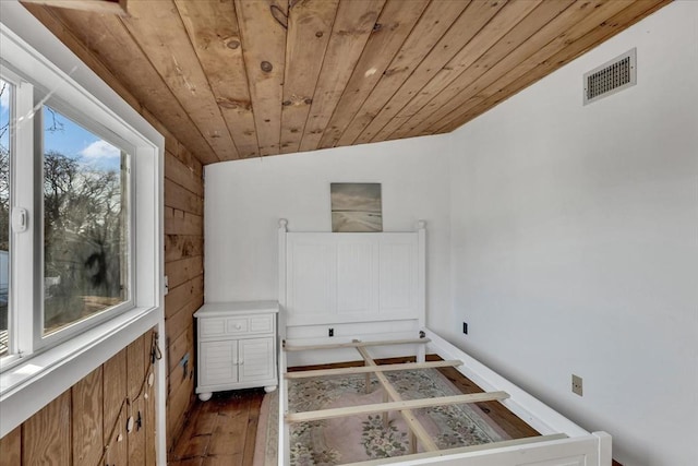 bedroom featuring lofted ceiling, wood walls, wood ceiling, and dark wood-type flooring