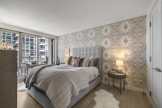 133 Seaport Blvd Unit 716, Boston, MA 02210 - bedroom featuring wallpapered walls, wood finished floors, and baseboards