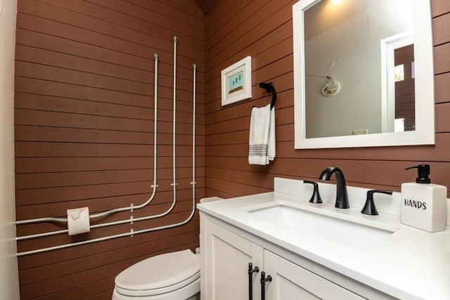 115 Lincoln Rd, Walpole, MA 02081 - bathroom featuring vanity, toilet, and wood walls