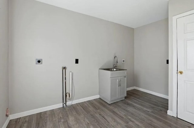 laundry area featuring cabinets, electric dryer hookup, sink, and hardwood / wood-style floors