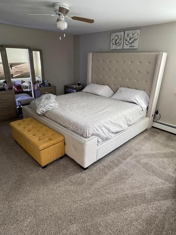 carpeted bedroom with ceiling fan and a baseboard radiator