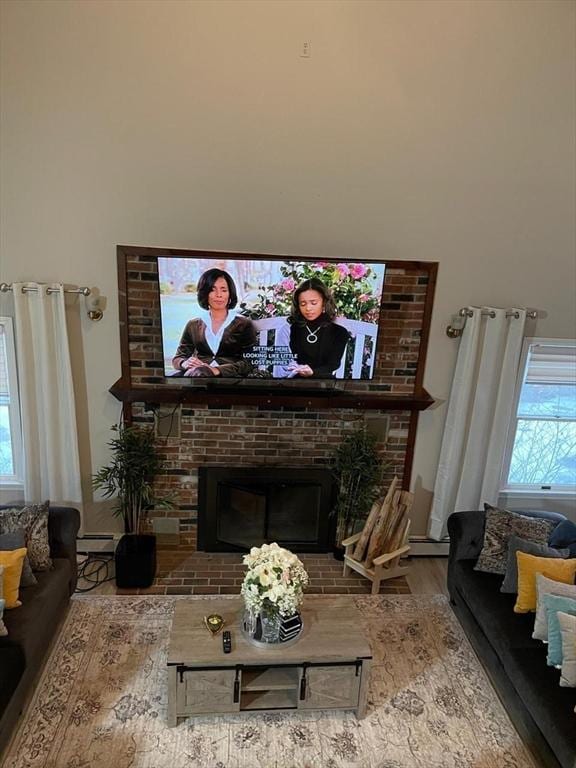 living room with hardwood / wood-style flooring, a healthy amount of sunlight, a fireplace, and baseboard heating