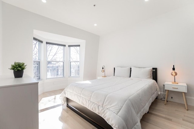 bedroom featuring baseboards, light wood-type flooring, and recessed lighting