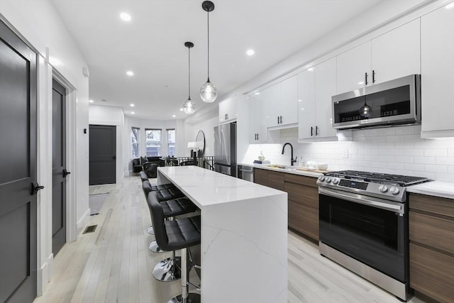 kitchen featuring white cabinetry, modern cabinets, appliances with stainless steel finishes, and a sink