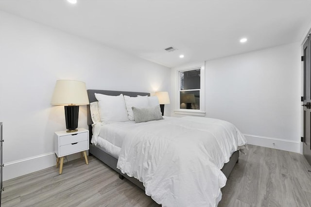 bedroom featuring visible vents, baseboards, wood finished floors, and recessed lighting