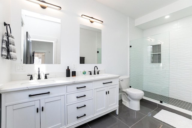 bathroom with a stall shower, a sink, toilet, and tile patterned floors