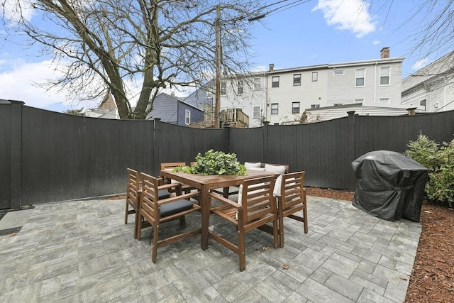 view of patio featuring outdoor dining area, grilling area, and a fenced backyard