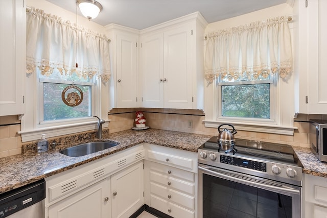 kitchen with stainless steel appliances, light stone countertops, backsplash, and white cabinets