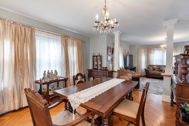 dining area with decorative columns, an inviting chandelier, and a healthy amount of sunlight