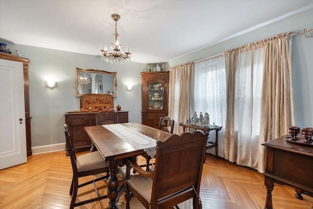 dining space with a notable chandelier and light parquet flooring