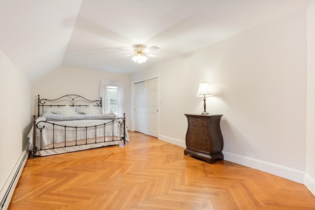 bedroom featuring a closet, baseboard heating, light parquet floors, and ceiling fan