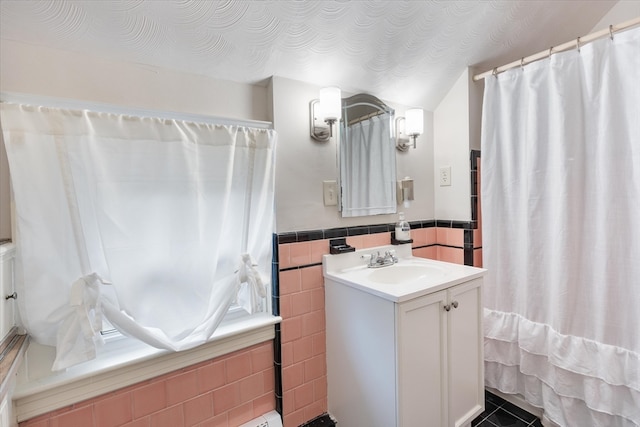 bathroom with tile patterned flooring, vanity, and tile walls