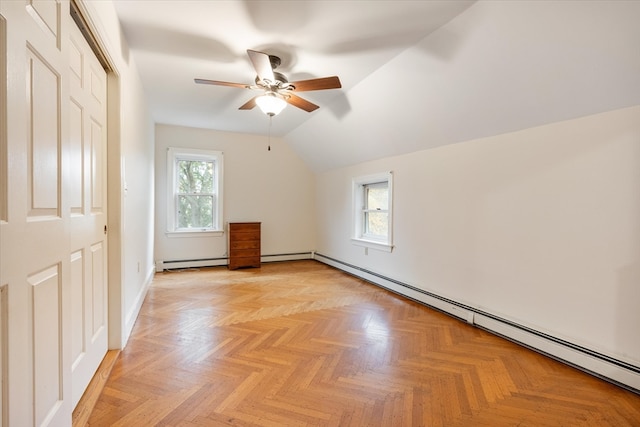 additional living space with ceiling fan, lofted ceiling, a wealth of natural light, and light parquet flooring