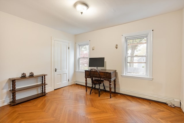 office space featuring baseboard heating, light parquet floors, and a healthy amount of sunlight