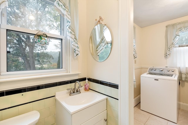 bathroom featuring tile patterned floors, washer / dryer, a wealth of natural light, and toilet