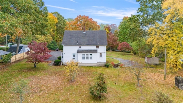 rear view of property featuring a lawn