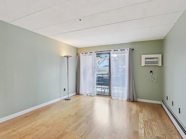 881 Broadway Unit 16, Everett, MA 02149 - unfurnished room with a baseboard radiator, a wall mounted air conditioner, and light wood-style flooring