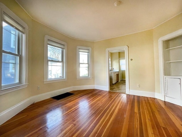 unfurnished room with wood-type flooring and baseboards