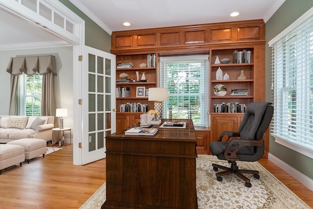 home office with ornamental molding and light hardwood / wood-style flooring