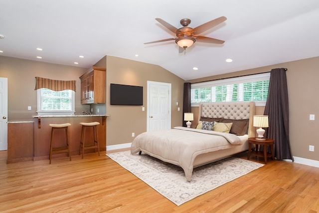 bedroom with ceiling fan, lofted ceiling, light wood-type flooring, and multiple windows