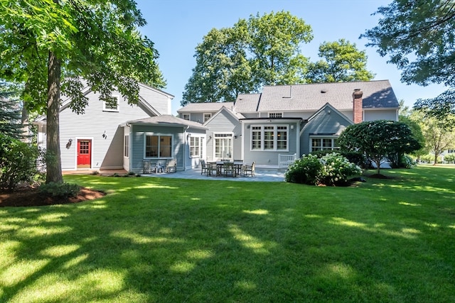 back of property featuring a yard and a patio