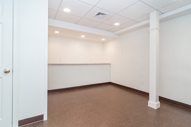 empty room featuring ornate columns and a drop ceiling