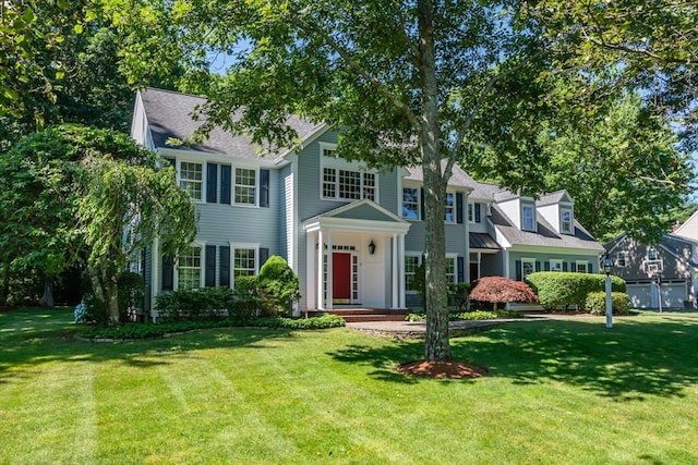 colonial-style house featuring a front lawn