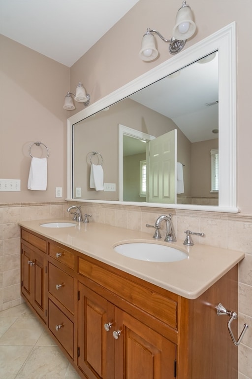 bathroom with tile patterned flooring, vanity, and tile walls