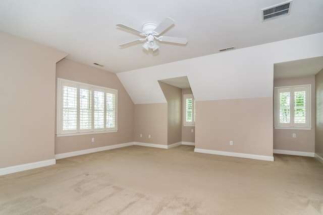 additional living space with ceiling fan, light colored carpet, and lofted ceiling