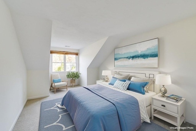 bedroom with vaulted ceiling and light colored carpet