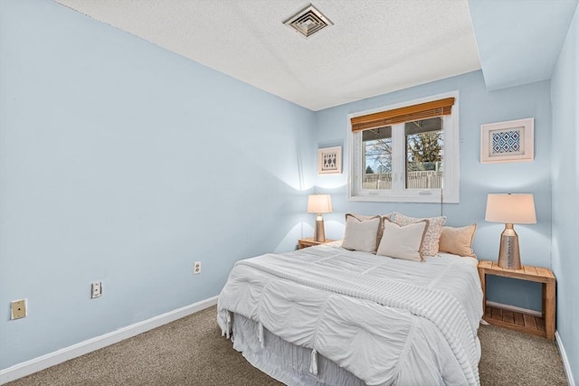 bedroom featuring a textured ceiling, carpet flooring, visible vents, and baseboards