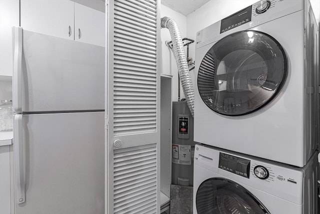 washroom with stacked washer and dryer, water heater, and laundry area