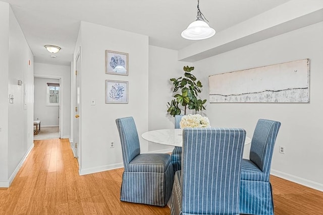 dining area featuring light wood-style floors and baseboards