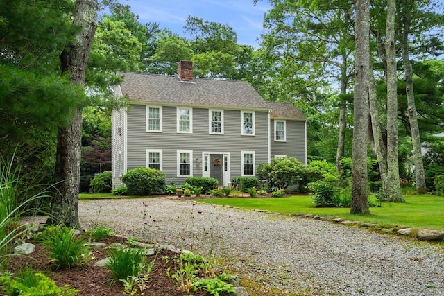 colonial home featuring a front lawn