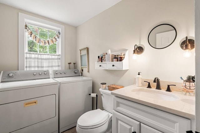 bathroom with vanity, toilet, and washing machine and dryer