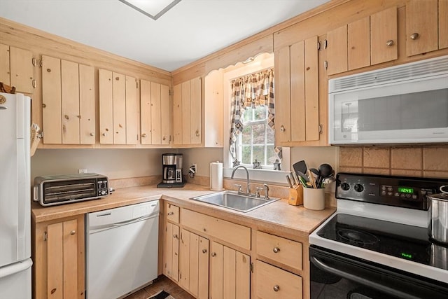 kitchen featuring tile patterned floors, light brown cabinets, white appliances, and sink