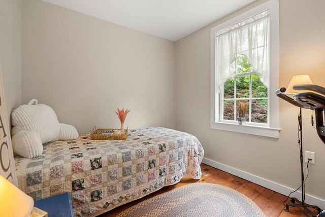 bedroom with wood-type flooring and multiple windows