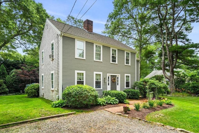 colonial inspired home featuring a front lawn