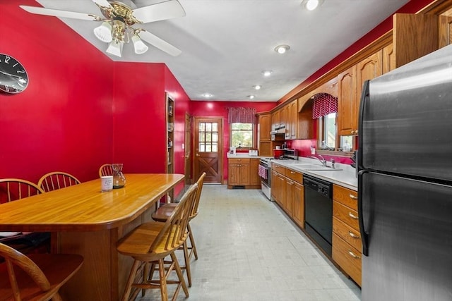 23 Essex St, Revere, MA 02151 - kitchen with black appliances, a kitchen bar, light floors, light countertops, and brown cabinetry
