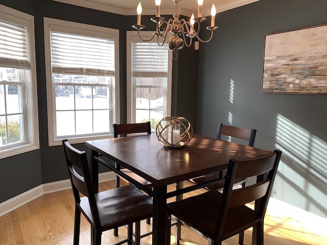 dining space with crown molding, a chandelier, a wealth of natural light, and light hardwood / wood-style floors