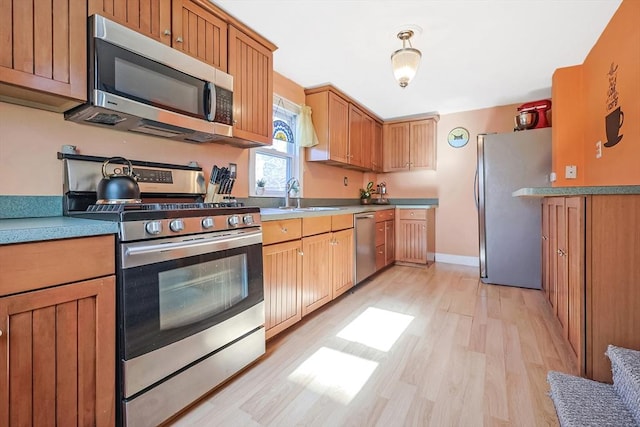 8 Scotia St, Salem, MA 01970 - kitchen featuring appliances with stainless steel finishes, light wood finished floors, a sink, baseboards, and light countertops