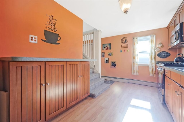 8 Scotia St, Salem, MA 01970 - kitchen featuring appliances with stainless steel finishes, a baseboard heating unit, brown cabinetry, and light wood-type flooring