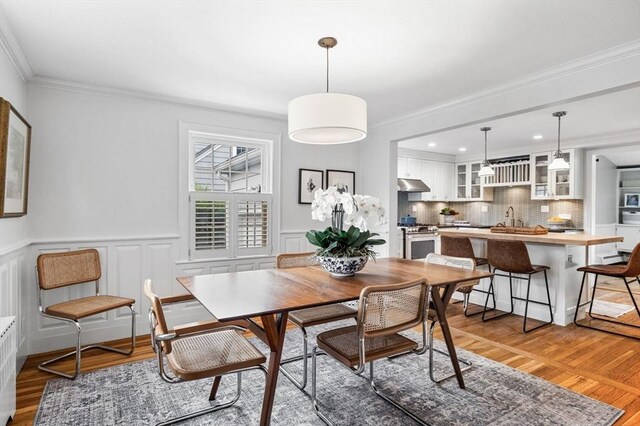 42 Pickwick Rd, Marblehead, MA 01945 - dining room with light wood finished floors, crown molding, wainscoting, and recessed lighting