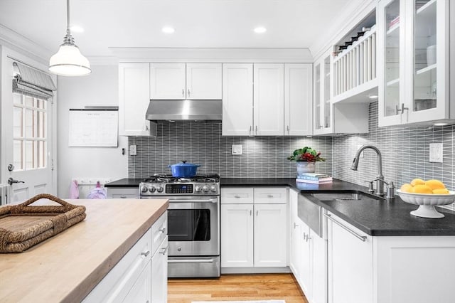 42 Pickwick Rd, Marblehead, MA 01945 - kitchen featuring under cabinet range hood, stainless steel gas range, ornamental molding, white cabinetry, and decorative light fixtures