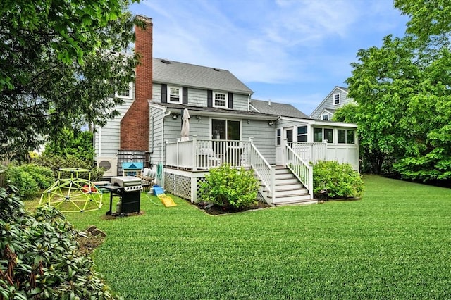 42 Pickwick Rd, Marblehead, MA 01945 - rear view of property featuring a sunroom, a chimney, a deck, a yard, and roof with shingles