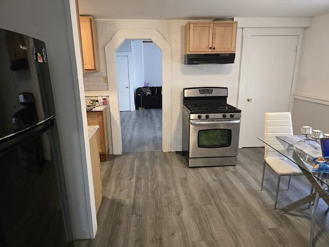 68 Temple St, Haverhill, MA 01832 - kitchen featuring stainless steel range with gas cooktop, freestanding refrigerator, dark wood-type flooring, under cabinet range hood, and arched walkways