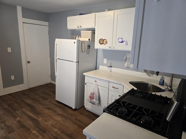 68 Temple St, Haverhill, MA 01832 - kitchen with freestanding refrigerator, black range with gas stovetop, dark wood-type flooring, white cabinets, and light countertops