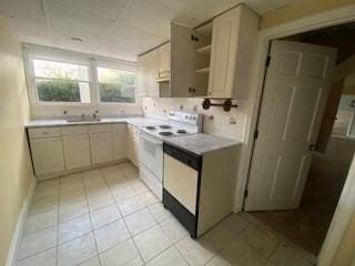 kitchen with light tile patterned flooring, white appliances, light countertops, and a sink